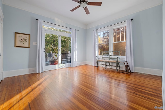 unfurnished room featuring hardwood / wood-style flooring, ceiling fan, and ornamental molding