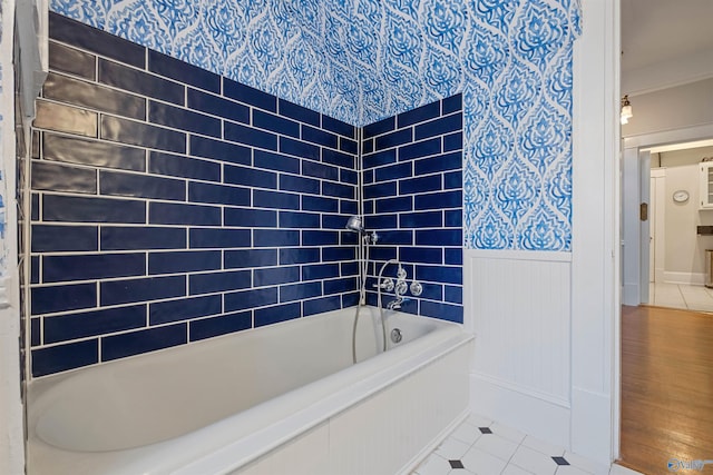 bathroom with hardwood / wood-style flooring, tiled shower / bath combo, and ornamental molding