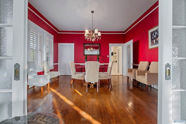 dining room featuring a chandelier, wood-type flooring, and crown molding