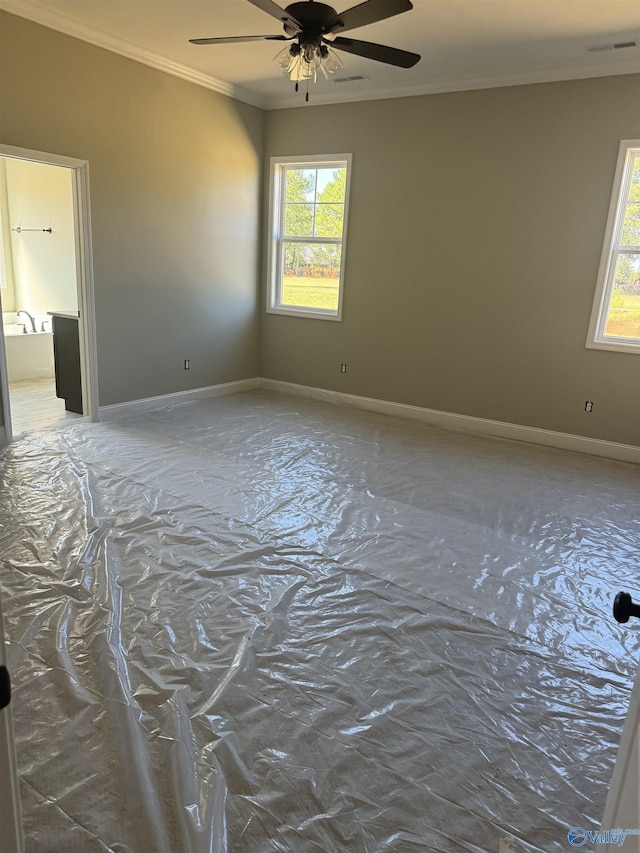 spare room featuring crown molding, a healthy amount of sunlight, and ceiling fan