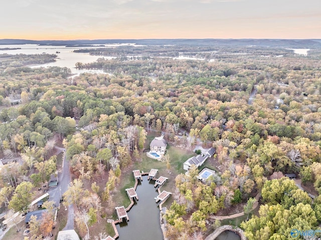 aerial view at dusk featuring a water view