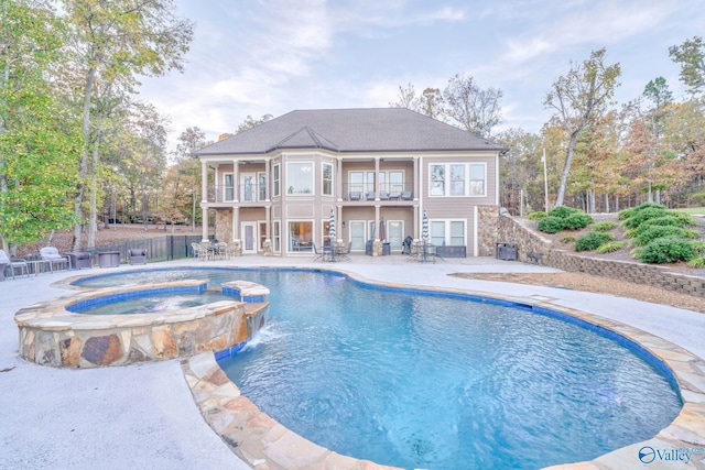 view of swimming pool with an in ground hot tub, pool water feature, and a patio area