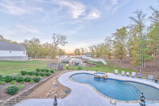 pool at dusk with a lawn, an in ground hot tub, and a patio