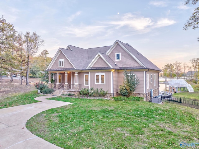 craftsman inspired home featuring a lawn, central air condition unit, and covered porch