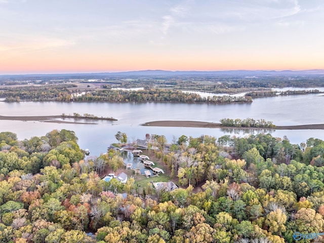 aerial view at dusk featuring a water view