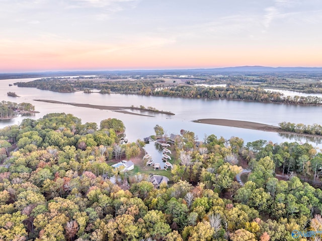 aerial view at dusk featuring a water view