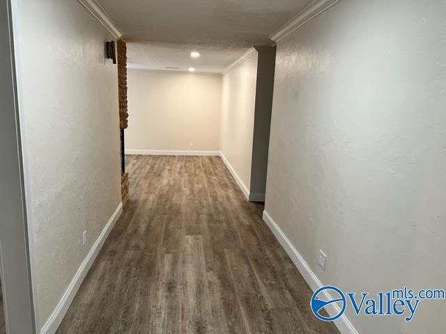 corridor with hardwood / wood-style floors and ornamental molding