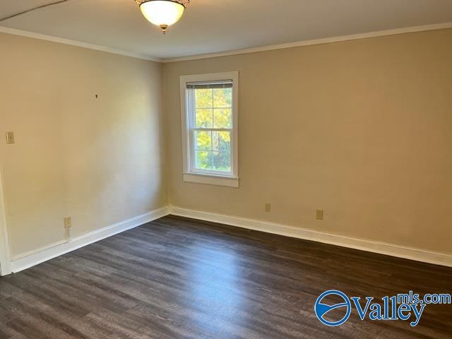 unfurnished room featuring crown molding and dark hardwood / wood-style floors