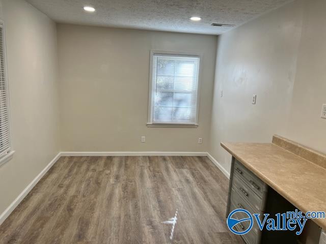 interior space featuring a textured ceiling and hardwood / wood-style floors