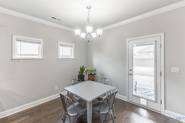 dining room featuring crown molding, dark wood-type flooring, and a chandelier