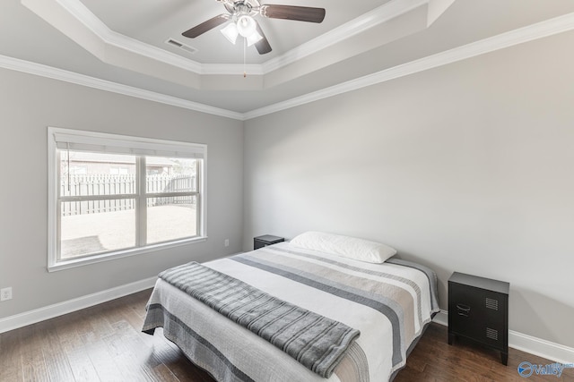 bedroom with dark hardwood / wood-style floors, a raised ceiling, ceiling fan, and crown molding