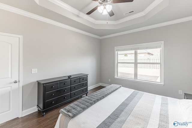 bedroom with ceiling fan, dark hardwood / wood-style floors, ornamental molding, and a tray ceiling