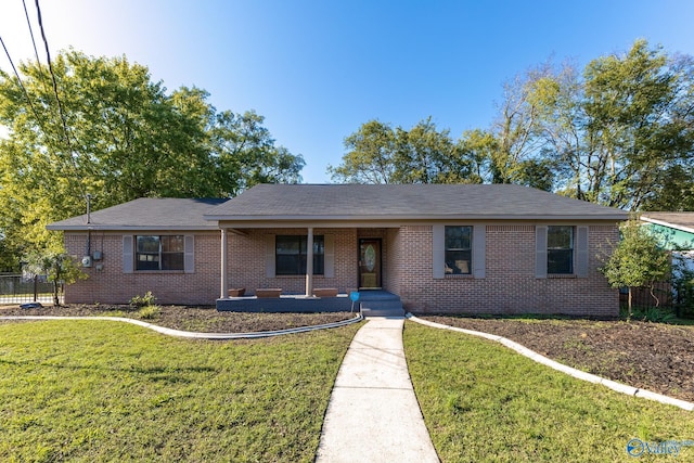 ranch-style house with covered porch, brick siding, and a front yard