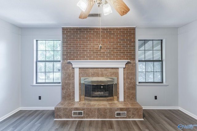 unfurnished living room featuring ceiling fan, a fireplace, and dark hardwood / wood-style floors