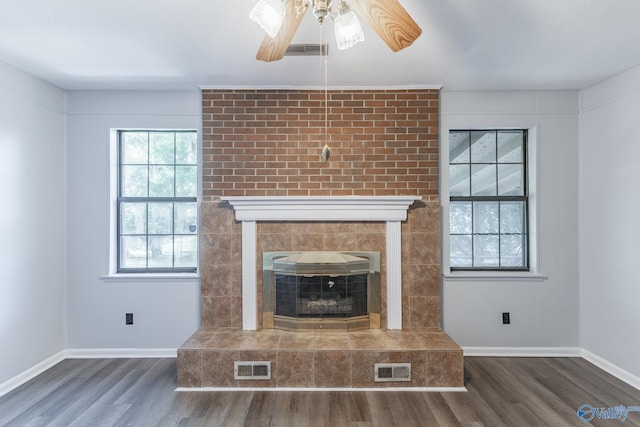 unfurnished living room featuring wood finished floors, a ceiling fan, visible vents, and baseboards