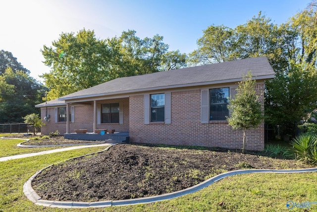ranch-style house featuring fence, a front yard, and brick siding