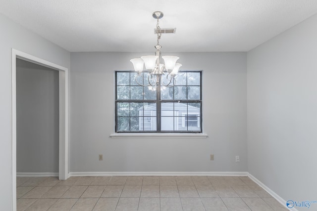 unfurnished dining area featuring a textured ceiling, an inviting chandelier, and light tile patterned floors