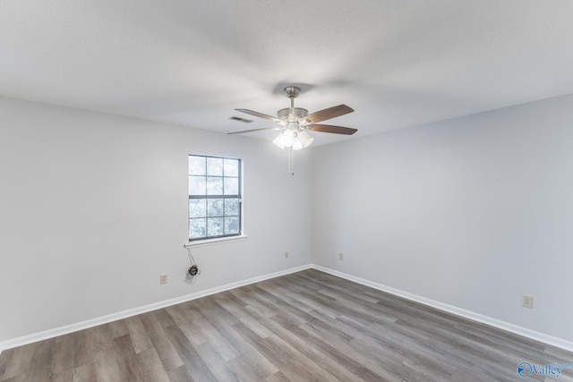 empty room featuring a textured ceiling, hardwood / wood-style floors, and ceiling fan