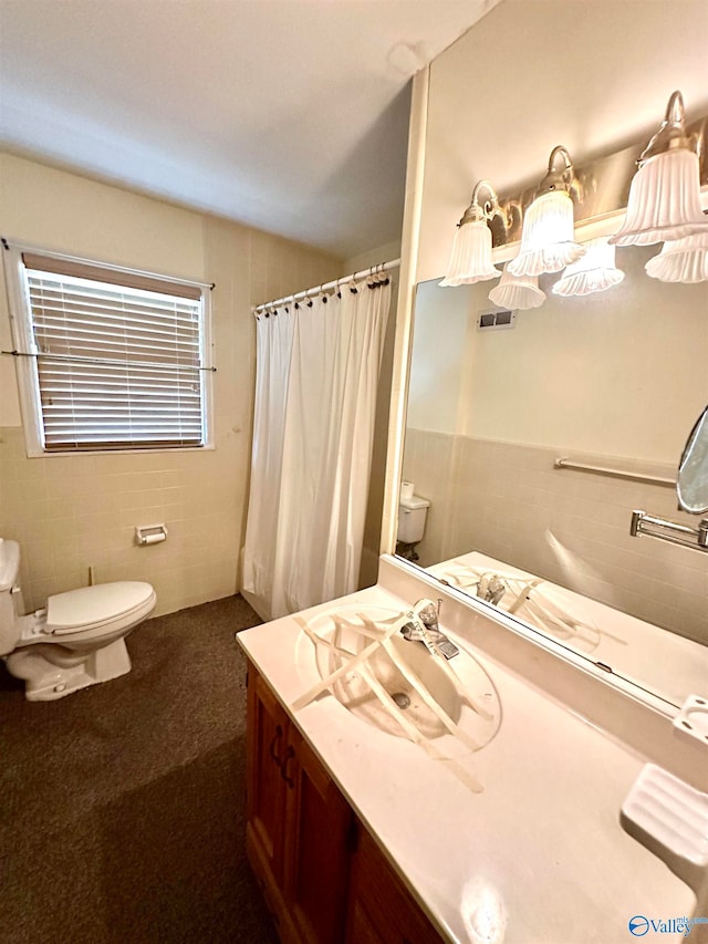 bathroom with vanity, toilet, a shower with curtain, and tile walls