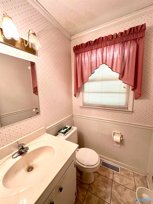 bathroom with tile patterned flooring, crown molding, toilet, vanity, and a textured ceiling