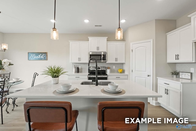 162 River Pointe Dr, New Market, AL 35761 - kitchen featuring stainless steel appliances, light wood-style flooring, pendant lighting, and decorative backsplash