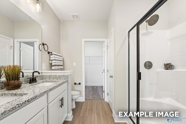 162 River Pointe Dr, New Market, AL 35761 - full bath with a stall shower, toilet, visible vents, a sink, and wood finished floors