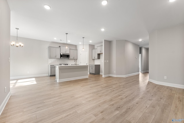 162 River Pointe Dr, New Market, AL 35761 - unfurnished living room featuring light wood-style flooring, a sink, baseboards, a chandelier, and recessed lighting