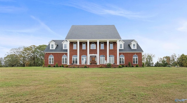 neoclassical home featuring brick siding and a front lawn