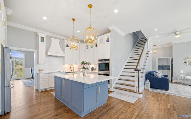 kitchen with glass insert cabinets, light countertops, white cabinets, and custom range hood