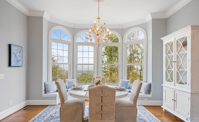 dining room with plenty of natural light, an inviting chandelier, and wood finished floors