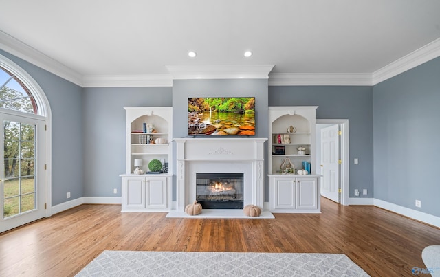 unfurnished living room with crown molding, wood finished floors, a glass covered fireplace, and baseboards