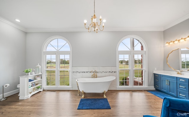 full bath with a soaking tub, plenty of natural light, vanity, and wood finished floors