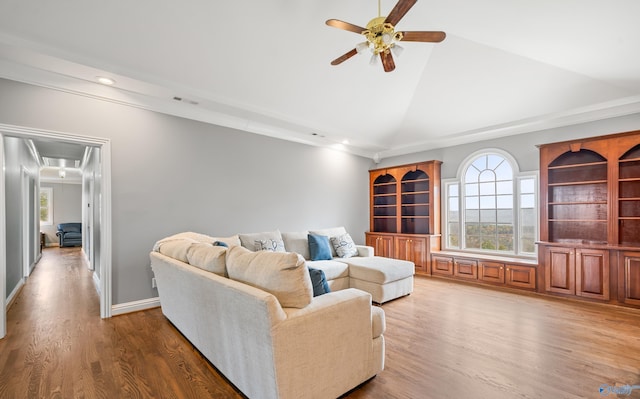 living room featuring high vaulted ceiling, attic access, a ceiling fan, and wood finished floors