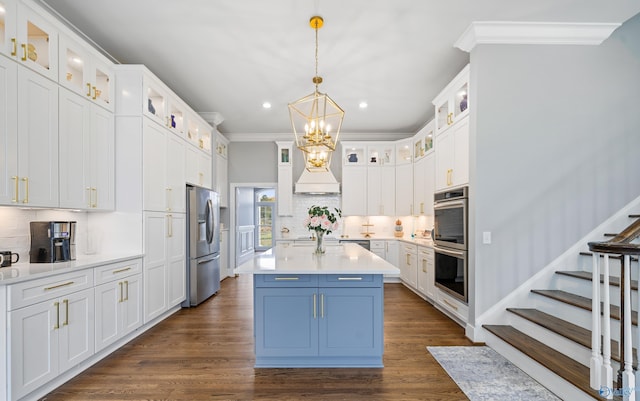 kitchen with stainless steel appliances, light countertops, hanging light fixtures, glass insert cabinets, and white cabinets