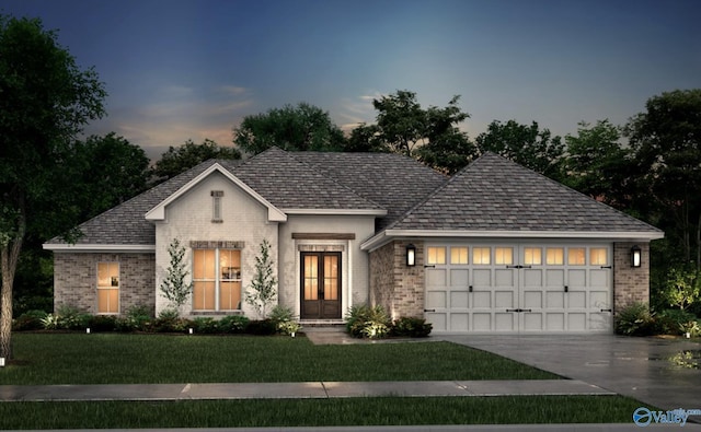 view of front facade featuring a garage, a yard, and french doors