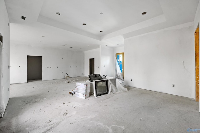 unfurnished living room with a tray ceiling