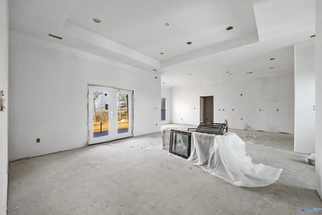 unfurnished living room with a raised ceiling and french doors