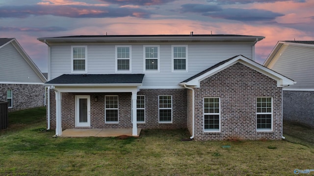 114 Harvest Moon Dr, Harvest, AL 35749 - back of house at dusk featuring brick siding, a patio area, and a yard