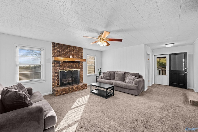 living room with a brick fireplace, a wealth of natural light, and carpet