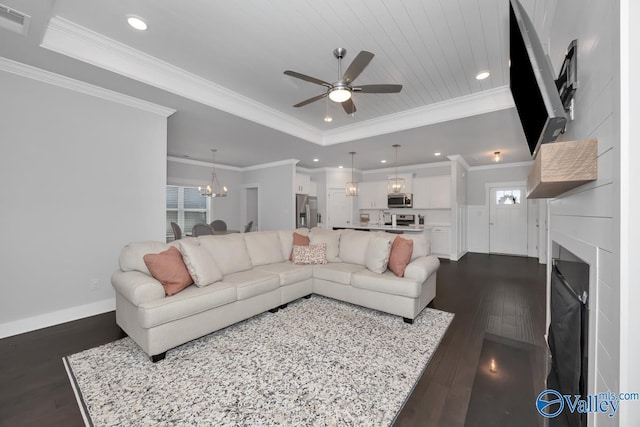 living room with a raised ceiling, ornamental molding, ceiling fan with notable chandelier, wood ceiling, and dark wood-type flooring