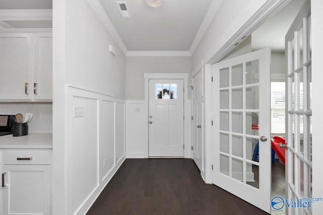 entryway with ornamental molding and dark wood-type flooring