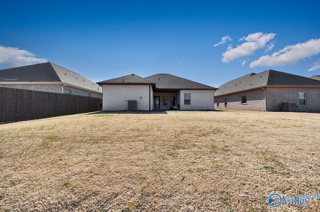 back of house featuring cooling unit and a lawn