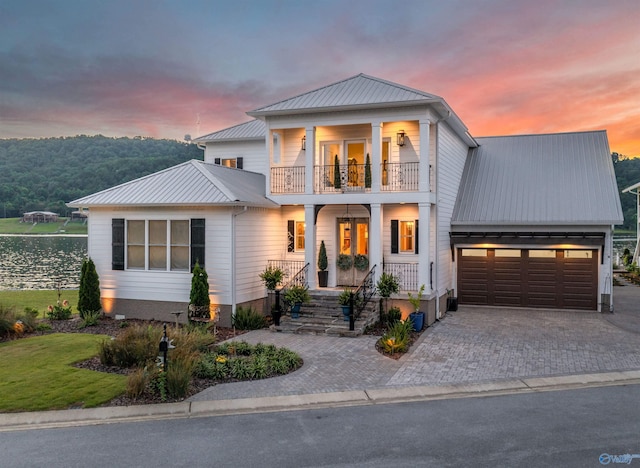 view of front of home featuring a balcony, a garage, and covered porch