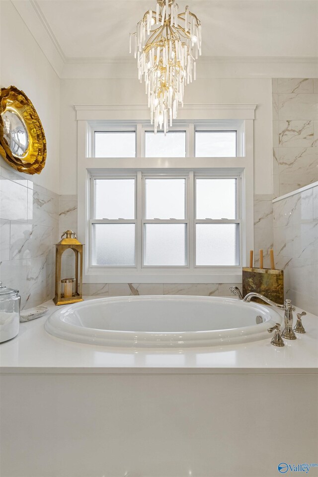 bathroom featuring ornamental molding, a bathing tub, and a chandelier