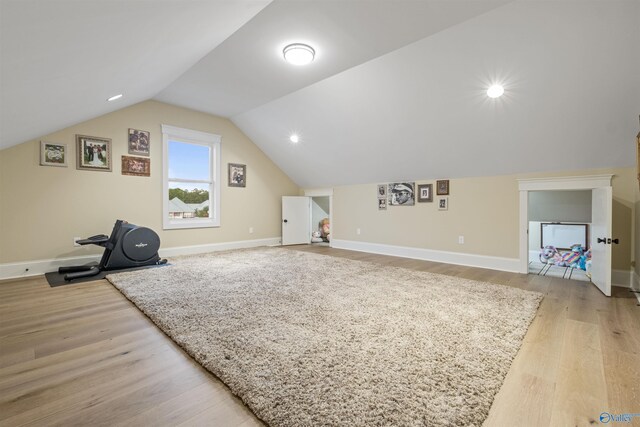 bonus room with vaulted ceiling and light wood-type flooring