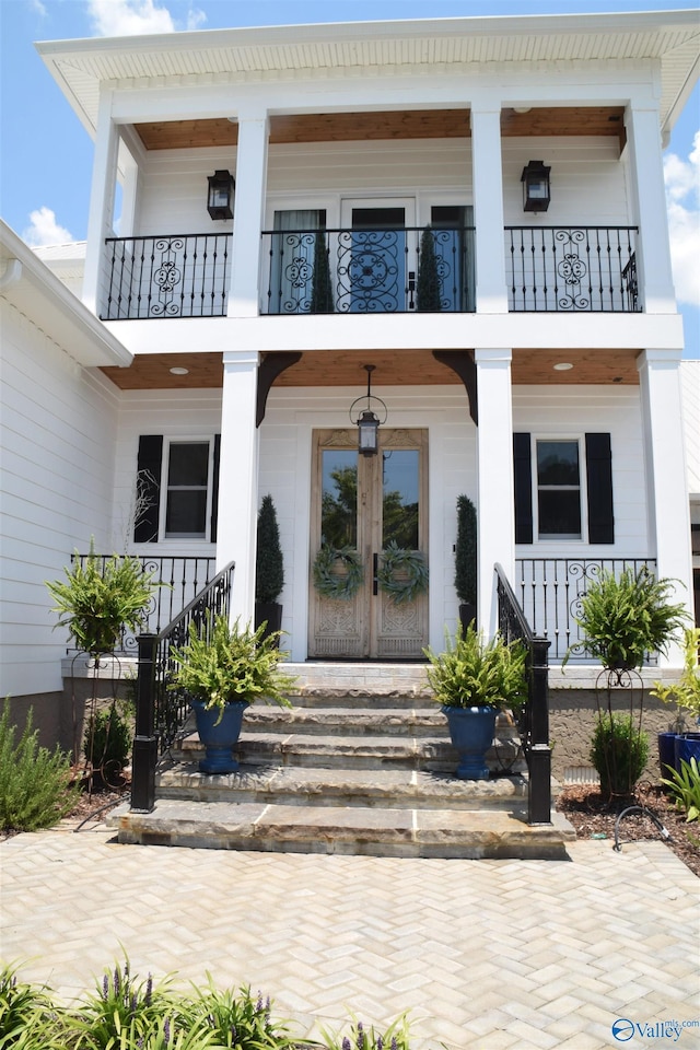 doorway to property with a balcony and french doors