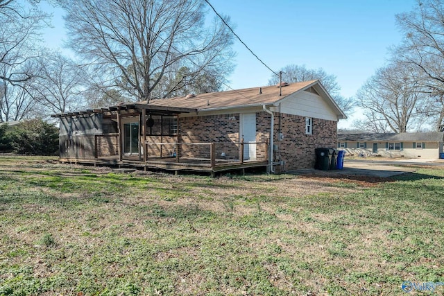 rear view of house with a yard and a wooden deck