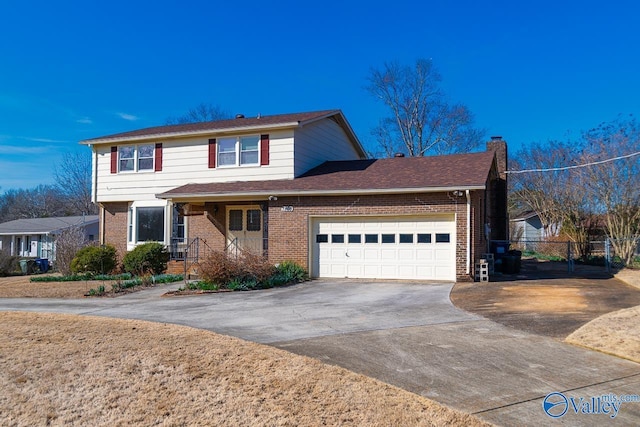 traditional home featuring driveway, a chimney, an attached garage, fence, and brick siding