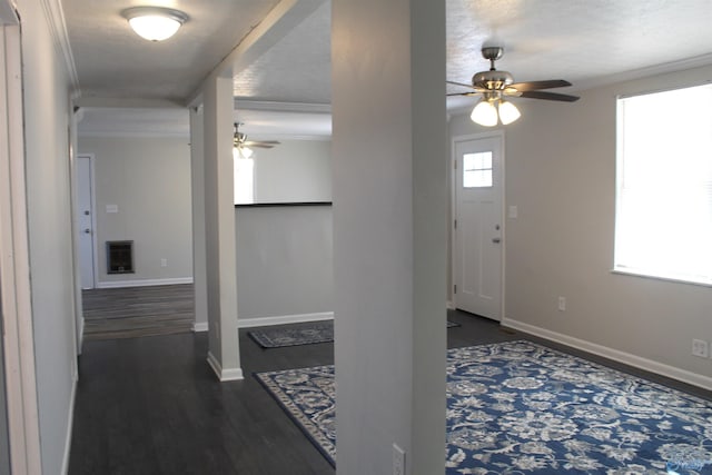 foyer entrance with ornamental molding, dark wood-type flooring, a textured ceiling, and ceiling fan