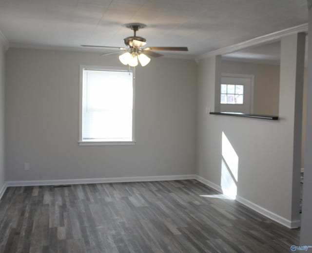 empty room featuring ceiling fan, crown molding, and dark wood-type flooring